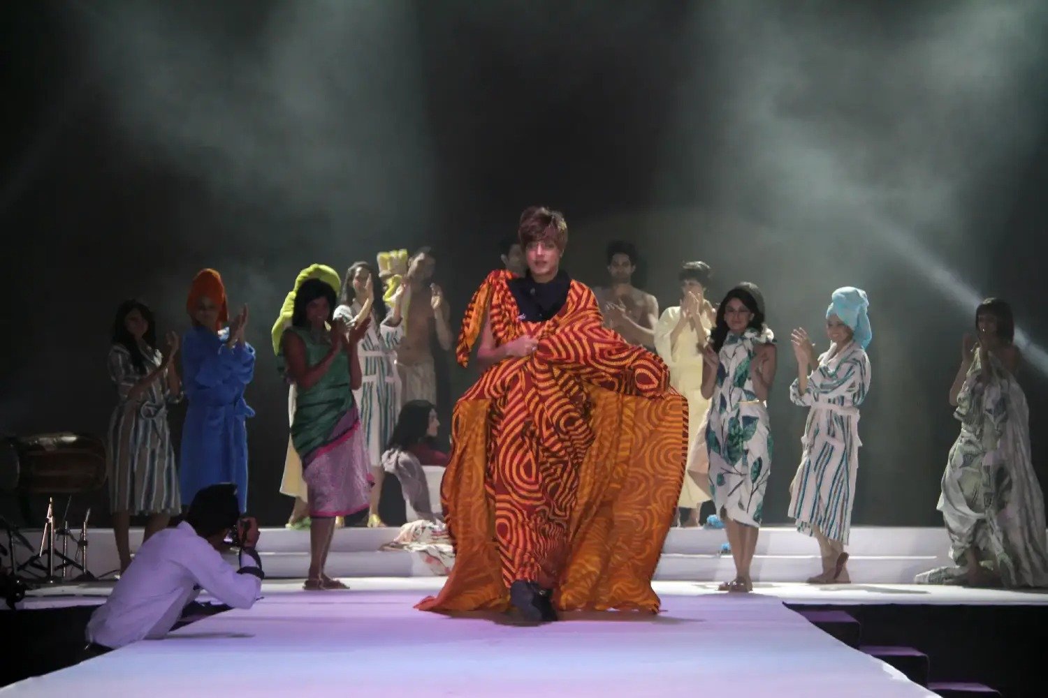 Musical performance on stage with three performers and ITT banner in background
